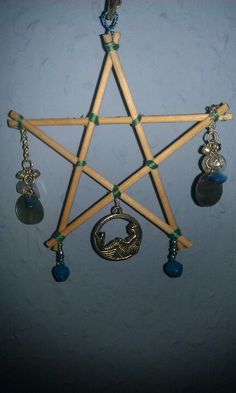 a wooden pentagram with several charms hanging from it