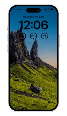 an iphone with the time displayed on it's screen and mountains in the background