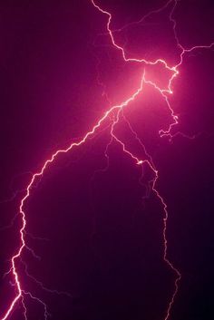 lightning strikes in the night sky with purple hues