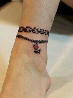 a woman's foot with a chain and heart tattoo on her left side ankle