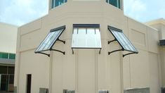 the front of a building with two windows and an awning on it's side