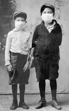 two children wearing masks and standing next to each other