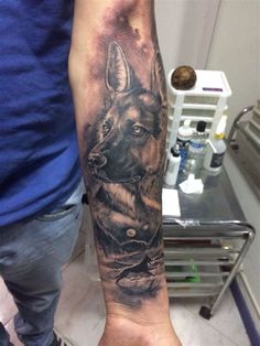 a man with a tattoo on his arm holding a dog's head in front of him