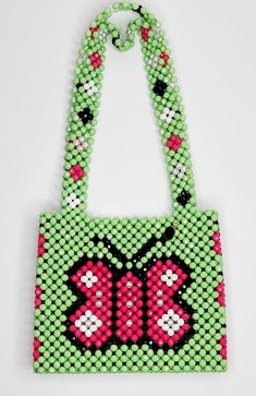 a green bag with pink and black beads on it