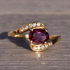 The 169th Avenue: Deep Pink Tourmaline And Natural Diamond Ring In Yellow Gold. The Ring Features An Oval Brilliant-Cut Natural Deep Pink Tourmaline, Set Horizontally Between A Bypass-Style Shank. The Shank Is Adorned With Ten (10) Channel-Set Round Brilliant-Cut Natural Diamonds, With Five On Each Side Above And Below The Center Stone. Crafted In 14 Karat Yellow Gold, The Ring Is Currently Sized At 6.5 But Can Be Adjusted To Fit Any Finger Size For An Additional Charge Upon Request. Yellow Gold Color, Natural Diamond Ring, Deep Pink, Channel Set, Pink Tourmaline, Purple Gold, Womens Jewelry Rings, Round Brilliant, Natural Diamonds