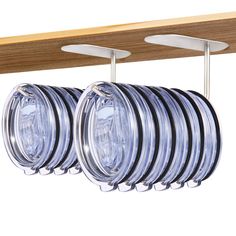 several clear glass plates hanging from a wooden shelf