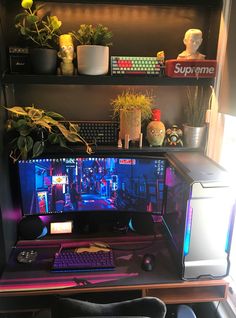 a computer desk with a keyboard and monitor on it, surrounded by potted plants