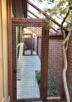 a gated entrance to a house with a small tree in the yard next to it