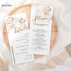 two wedding menus sitting on top of a wooden plate