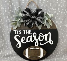 a wooden sign that says tis the season with a football and succulents