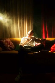 a person sitting on a couch in the dark