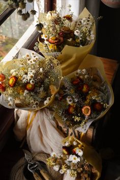 three bouquets of flowers sitting on top of a window sill next to each other