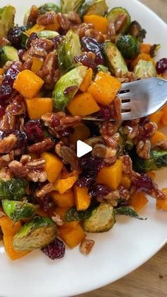 a white plate topped with brussel sprouts and oranges