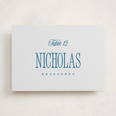 a white business card with blue lettering that reads, table 12 nicholas boucheron