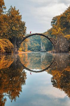 a bridge that is over some water with trees in the background