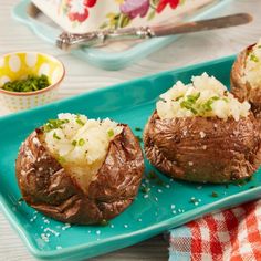 three baked potatoes sitting on a blue plate