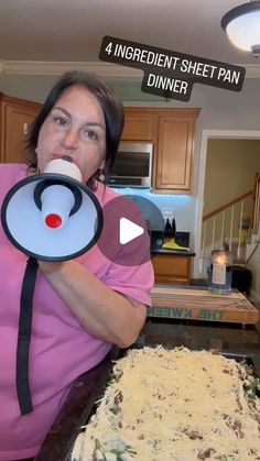 a woman in pink shirt holding up a pan with food on it and an object that says, 4 ingredient sheet pan dinner