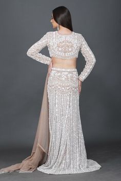 Beige and ivory lehenga crafted in net with all over gullista embroidery using tonal white sequins, cutdana, pearls highlights. Paired with a matching full sleeves high round neck embroidered blouse and a beige net dupatta with glass bead tassel embellishments. - Aza Fashions White Embellished Pre-draped Saree For Wedding, White Floor-length Choli For Reception, Fitted White Choli For Reception, White Embellished Floor-length Sets, White Fitted Sets For Reception, Off White Pre-draped Saree For Wedding, Fitted Embellished White Lehenga, Fitted White Embellished Traditional Wear, White Embellished Fitted Traditional Wear