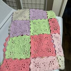 a crocheted blanket sitting on top of a toilet