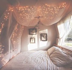 an image of a bedroom with lights on the ceiling and curtains over the bed,