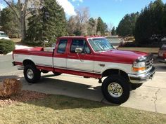 a red and white truck parked on the side of a road