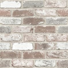 an old brick wall with white and brown bricks