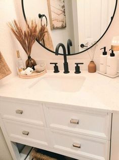 a bathroom sink with a round mirror above it