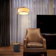 a living room with a chair, lamp and television