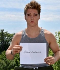 a young man is holding up a sign