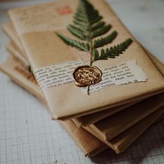 there are three pieces of paper with leaves on them and one has a wax stamp