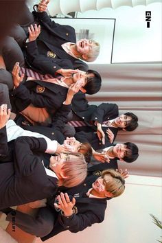 several women in suits and ties are posing for a photo together with their hands up