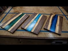 five pieces of wood sitting on top of a wooden table with blue and green paint