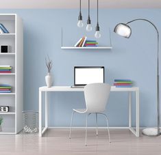 a white desk with a computer on top of it in front of a bookshelf