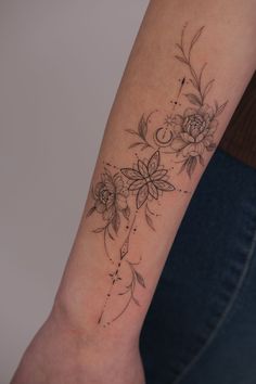 a woman's arm with flowers and leaves tattoo on the left side of her arm