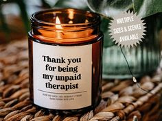 a candle that is sitting on top of a wicker mat with the words thank you for being my unpaid therapist