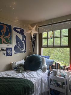 a bed room with a neatly made bed and pictures on the wall next to it