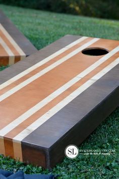 two wooden boards sitting in the grass near each other, one has a hole in it