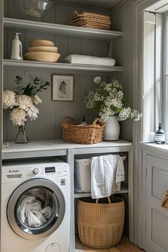 a washer and dryer sitting in a room next to a window with flowers