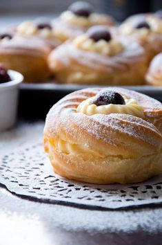 several pastries sitting on top of a table next to bowls of fruit and bread