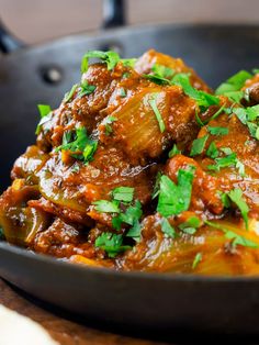 beef bhuna curry in a skillet with cilantro and parsley