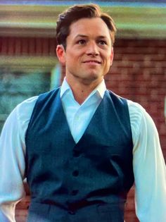 a man wearing a blue vest and white shirt