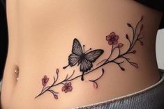 a woman's stomach with a butterfly tattoo on the side and pink flowers around it