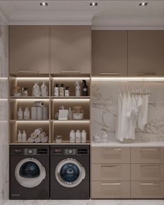 a washer and dryer in a bathroom next to cabinets with clothes hanging on them