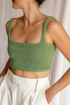 a woman wearing a green crop top and white shorts