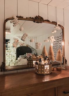 a mirror sitting on top of a wooden dresser next to a christmas tree and other decorations