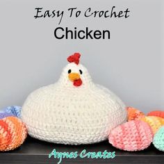 an easy to crochet chicken sits next to balls of yarn