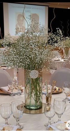 a vase filled with baby's breath sitting on top of a white table cloth