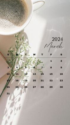 a cup of coffee sitting next to a calendar