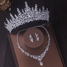 a tiara and earrings are on display in a box next to a flower arrangement