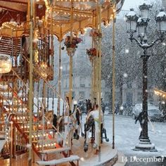 a merry go round in the snow with people on it